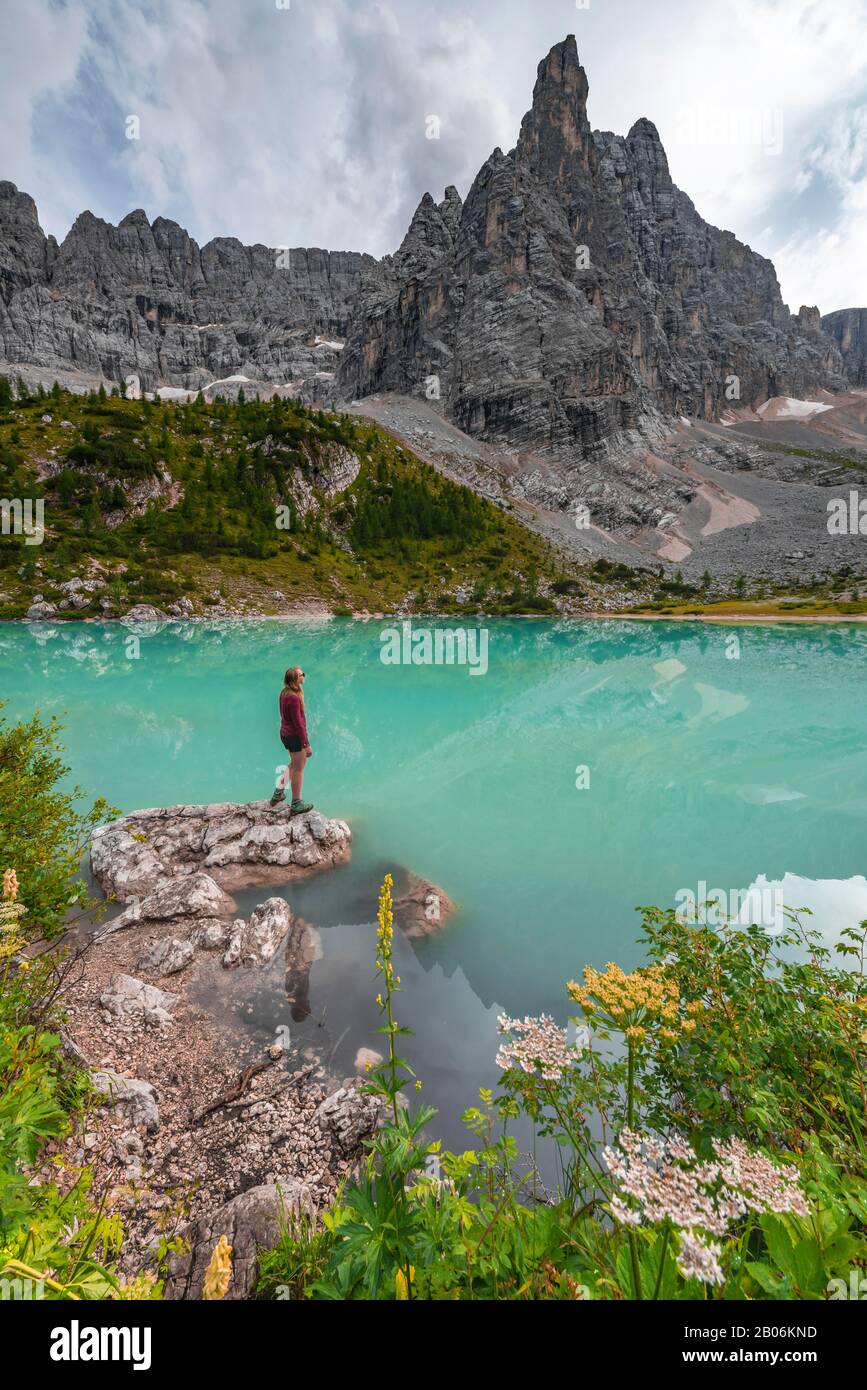 Jeune femme, randonneur au lac de Sorapis vert turquoise, Lago di Sorapis, pic de montagne Dito di Dio, Dolomites, Belluno, Italie Banque D'Images
