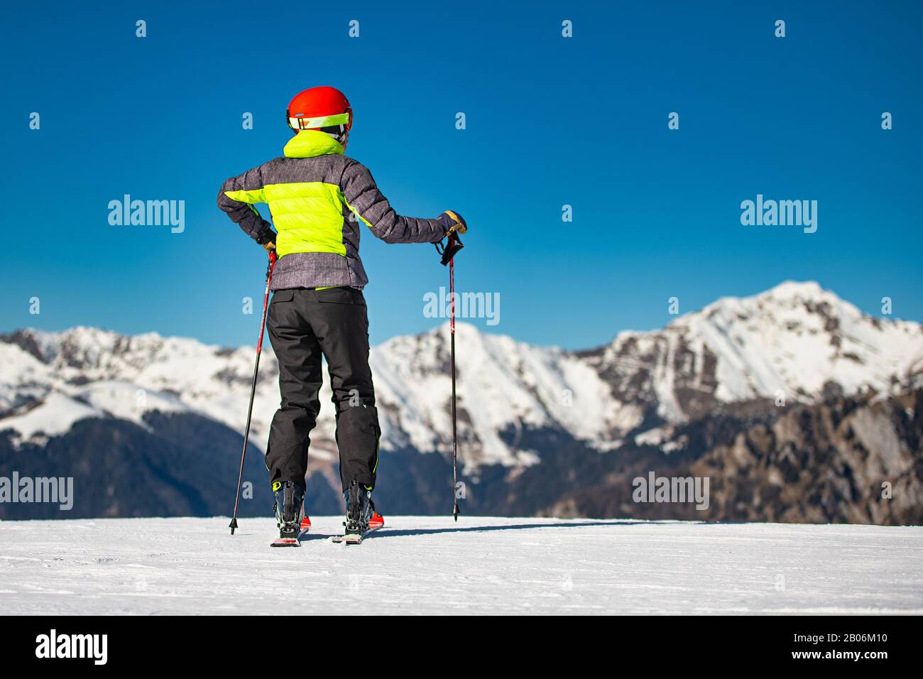 Sur les pistes de ski d'un domaine skiable, un skieur regarde les montagnes avant de skier Banque D'Images