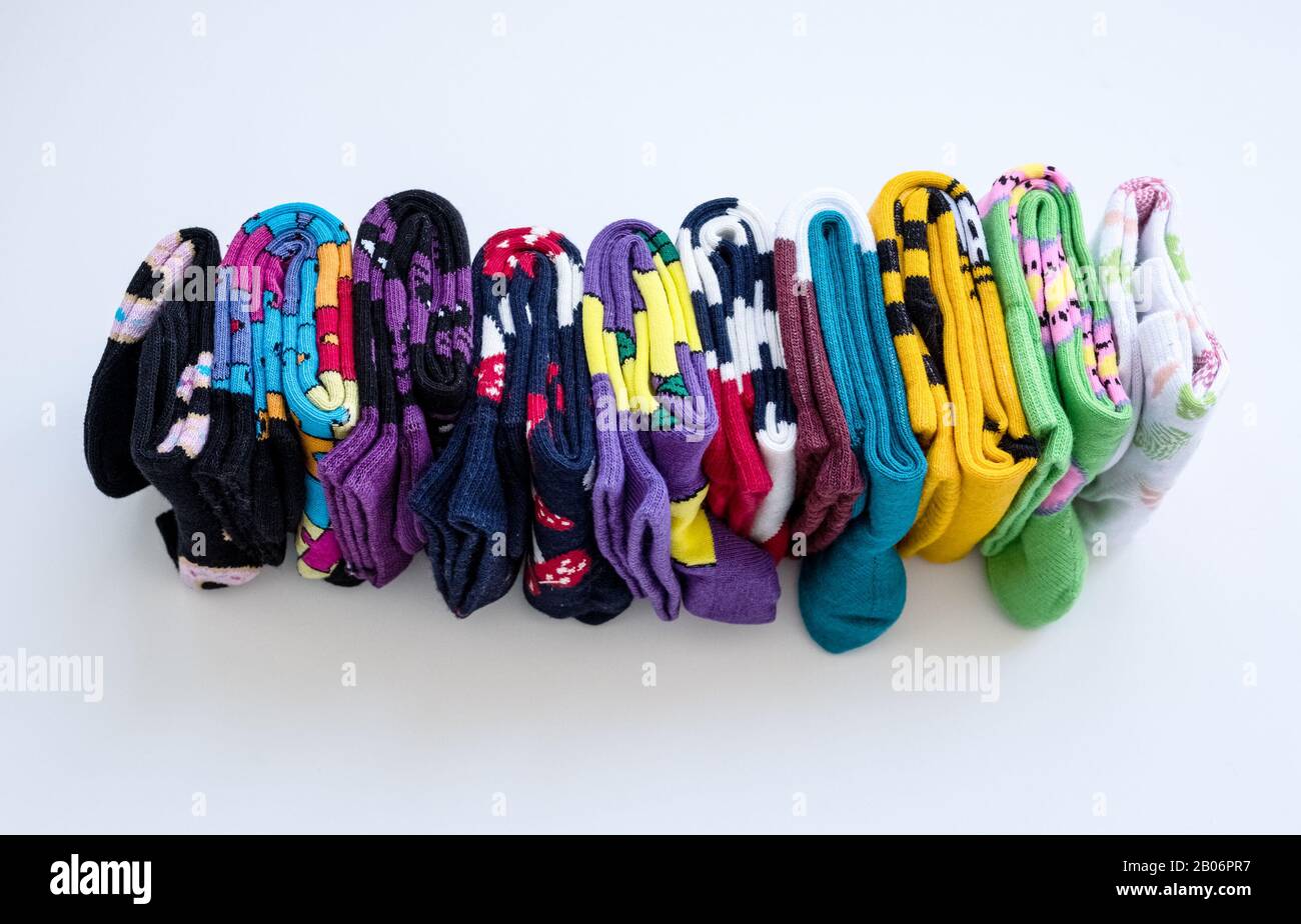 Plusieurs chaussettes en coton colorées roulent sur fond blanc. Banque D'Images