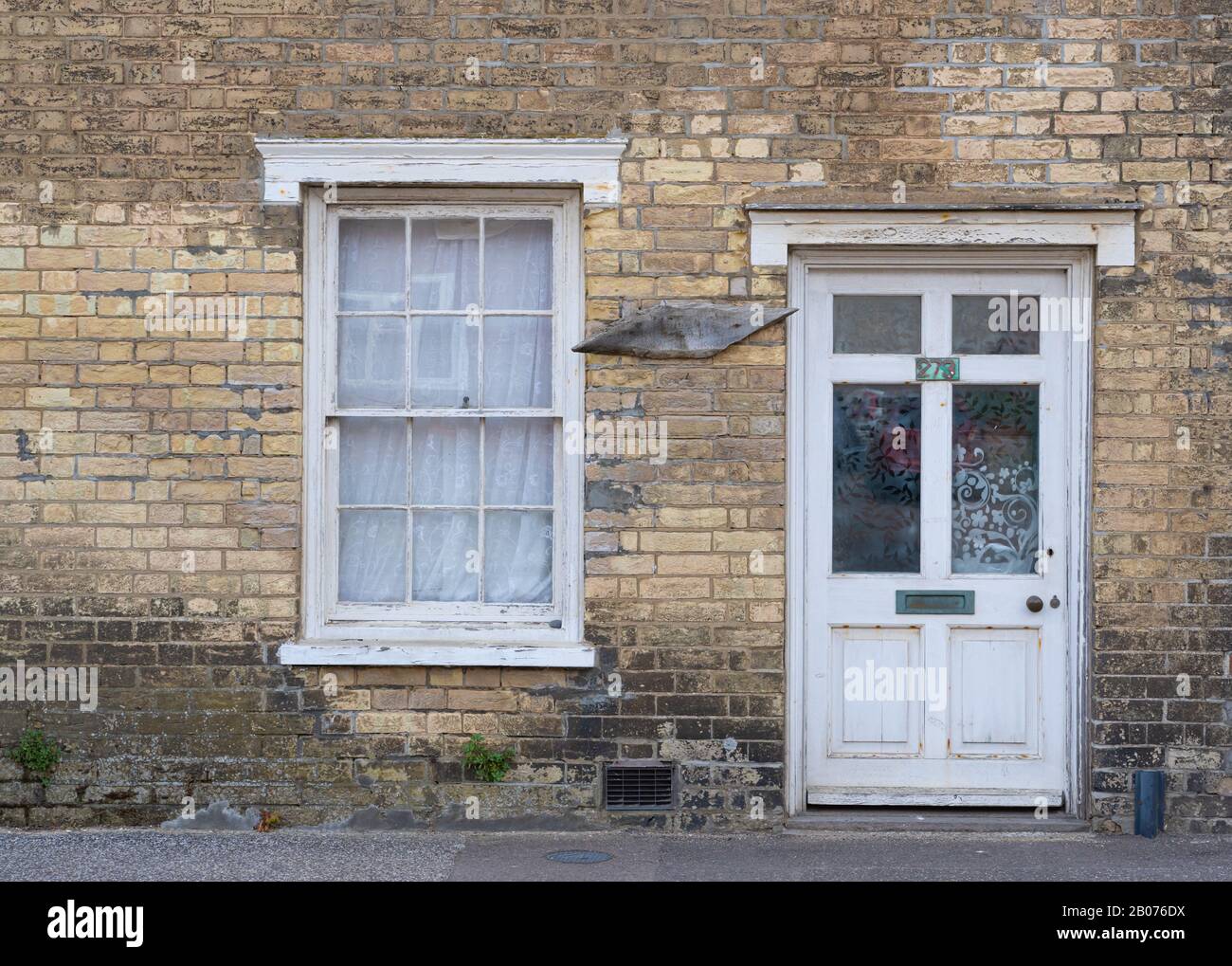 Porte avant et fenêtre de la maison dans le besoin de décoration. Aldeburgh, Suffolk. ROYAUME-UNI. Banque D'Images