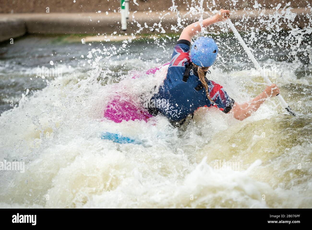 Athlète de GB Canoe Slalom en classe C1W en action sur l'eau blanche. Pagayage à l'écart et entouré d'éclaboussures. Banque D'Images