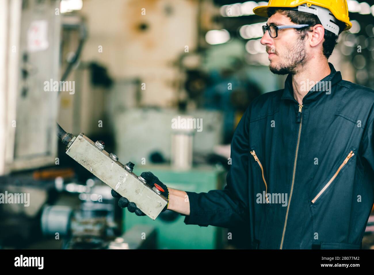 l'employé de l'usine a l'intention d'utiliser la machine, l'industrie du travail hautement qualifié avec des vêtements de sécurité. Banque D'Images