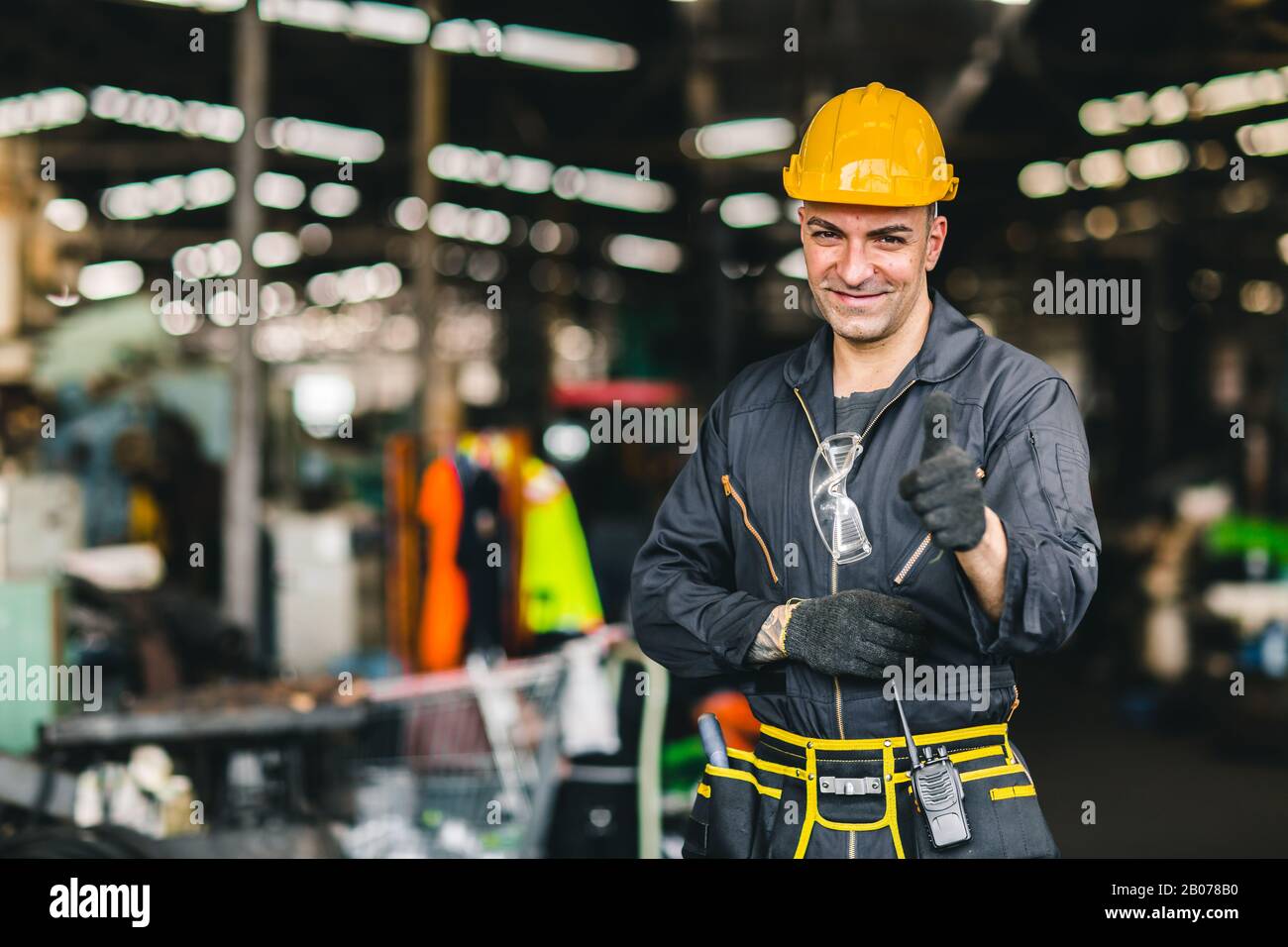 Portrait de l'ingénieur du travail du contremaître travaillant dans une usine industrielle et de la combinaison de sécurité waring Happy Smile main montrer pouce vers le haut. Banque D'Images