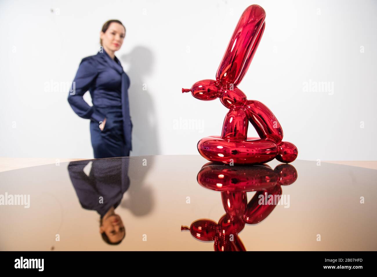 Un visiteur vues 'Balloon Rabbit (rouge), par Jeff Kons, une partie de l'exposition 'XXI' de l'exposition des œuvres non vues et rares par des tels que RETNA, Damien Hurst et Condo, Qui accompagne le lancement de l'ARTCELS, une plate-forme numérique pour les investissements d'art à puce bleue à la Maison des Beaux-Arts - HAFA Gallery à Londres jusqu'au 5 avril. Banque D'Images