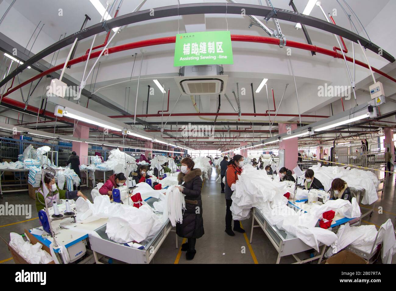 Les travailleurs chinois fabriquent des vêtements de protection médicale dans une usine de vêtements lors de l'éclosion du nouveau coronavirus et de la pneumonie dans la ville de Taizhou, Banque D'Images