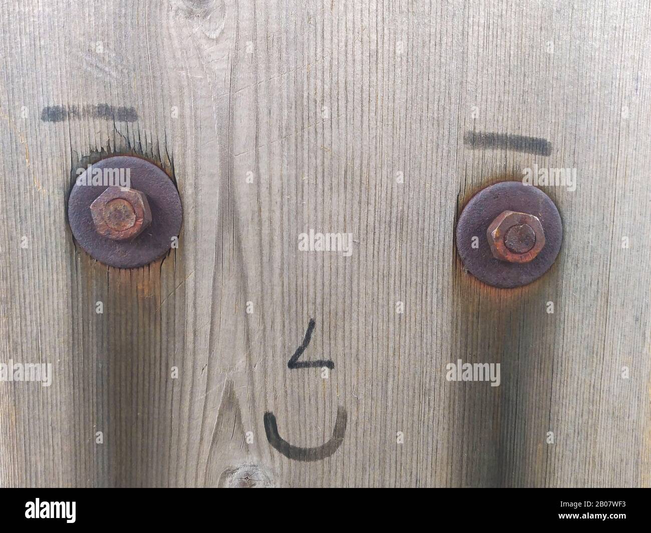Larmes de bonheur sur un visage en bois, pleurant et souriant en même temps. Banque D'Images