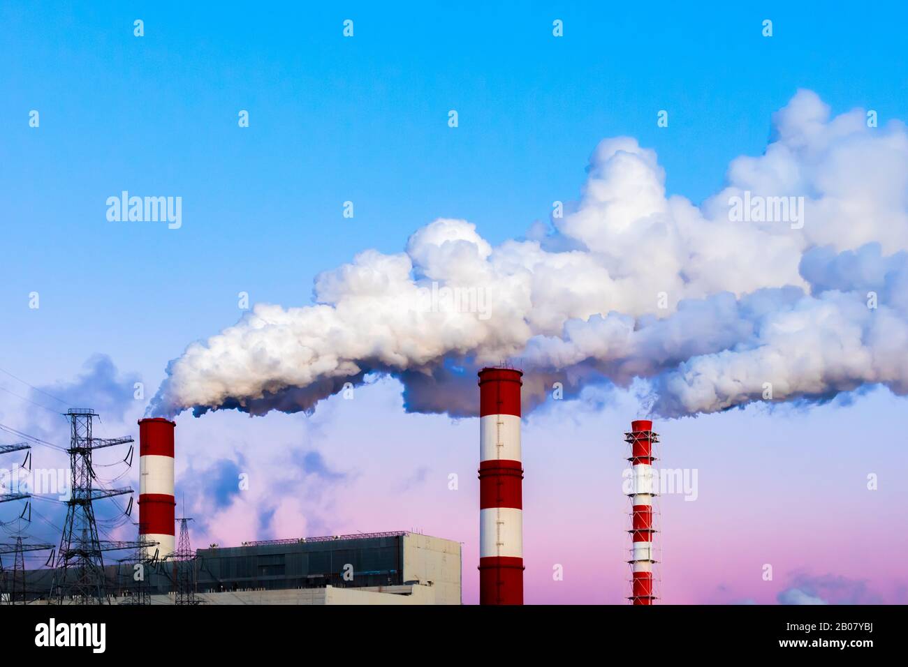 Les cheminées d'usine polluent l'air, la fumée épaisse sale, le ciel crépuscule du soir. Beau paysage industriel, pollution de l'environnement, air empoisonné Banque D'Images