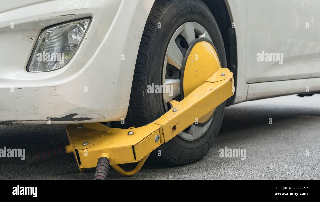 Roue de voiture bloquée par blocage de roue parce que le stationnement illégal violation Banque D'Images