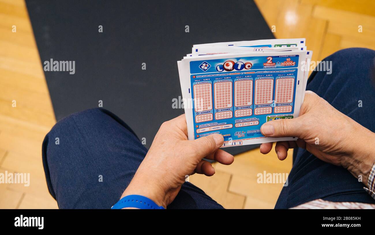Paris, France - 2 avril 2019 : vue aérienne des mains de sexe masculin principal tenant des billets Loto du système de loterie français FDJ Banque D'Images