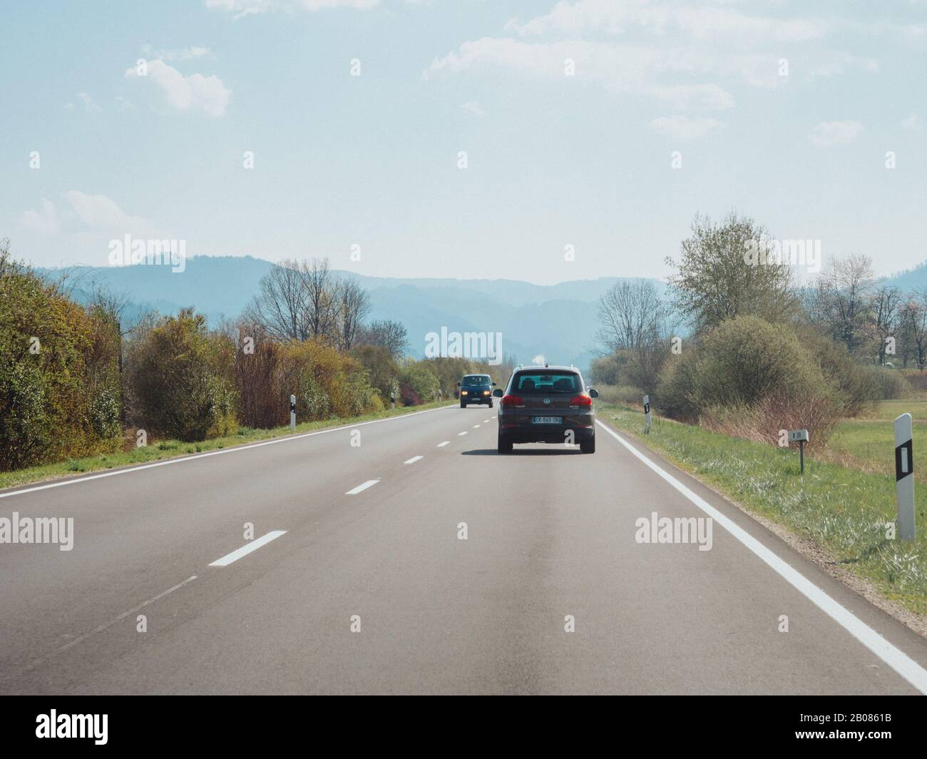 Allemagne - 31 mars 2019: Vue arrière du 4x4 Volkswagen Tiguan marron conduisant rapidement sur la route rurale avec des montagnes de forêt noire en arrière-plan couvert de brouillard Banque D'Images