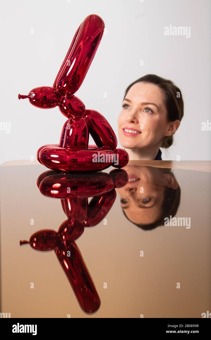 Un visiteur vues 'Balloon Rabbit (rouge), par Jeff Kons, une partie de l'exposition 'XXI' de l'exposition des œuvres non vues et rares par des tels que RETNA, Damien Hirst et Condo, Qui accompagne le lancement de l'ARTCELS, une plate-forme numérique pour les investissements d'art à puce bleue à la Maison des Beaux-Arts - HAFA Gallery à Londres jusqu'au 5 mars. Banque D'Images