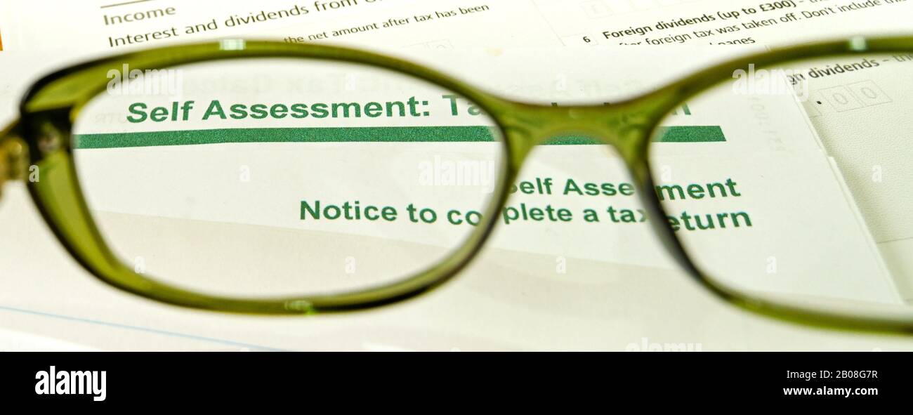 Vue rapprochée d'un formulaire de déclaration de revenus d'auto-évaluation vu à travers l'objectif d'une paire de lunettes Banque D'Images