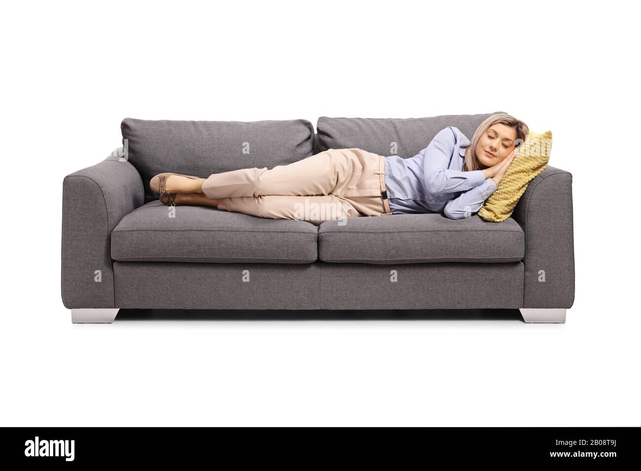 Une jeune femme fatiguée du travail dormant sur un canapé isolé sur fond blanc Banque D'Images