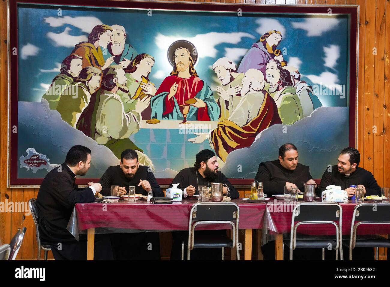 Les prêtres mangent le dîner sous une peinture à l'huile religieuse "La dernière Cène de Jésus" dans le séminaire catholique dans le district de Maadi, au Caire, en Egypte Banque D'Images