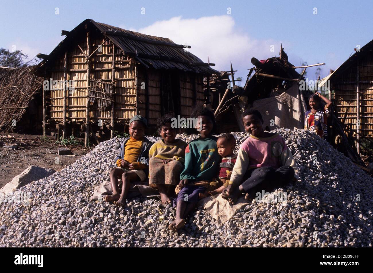 MADAGASCAR, PRÈS DE LA RÉSERVE DE PERINET, FORÊT PLUVIALE, CARRIÈRE DE GRAVIER, ENFANTS LOCAUX, ARRIÈRE-PLAN HUTS Banque D'Images