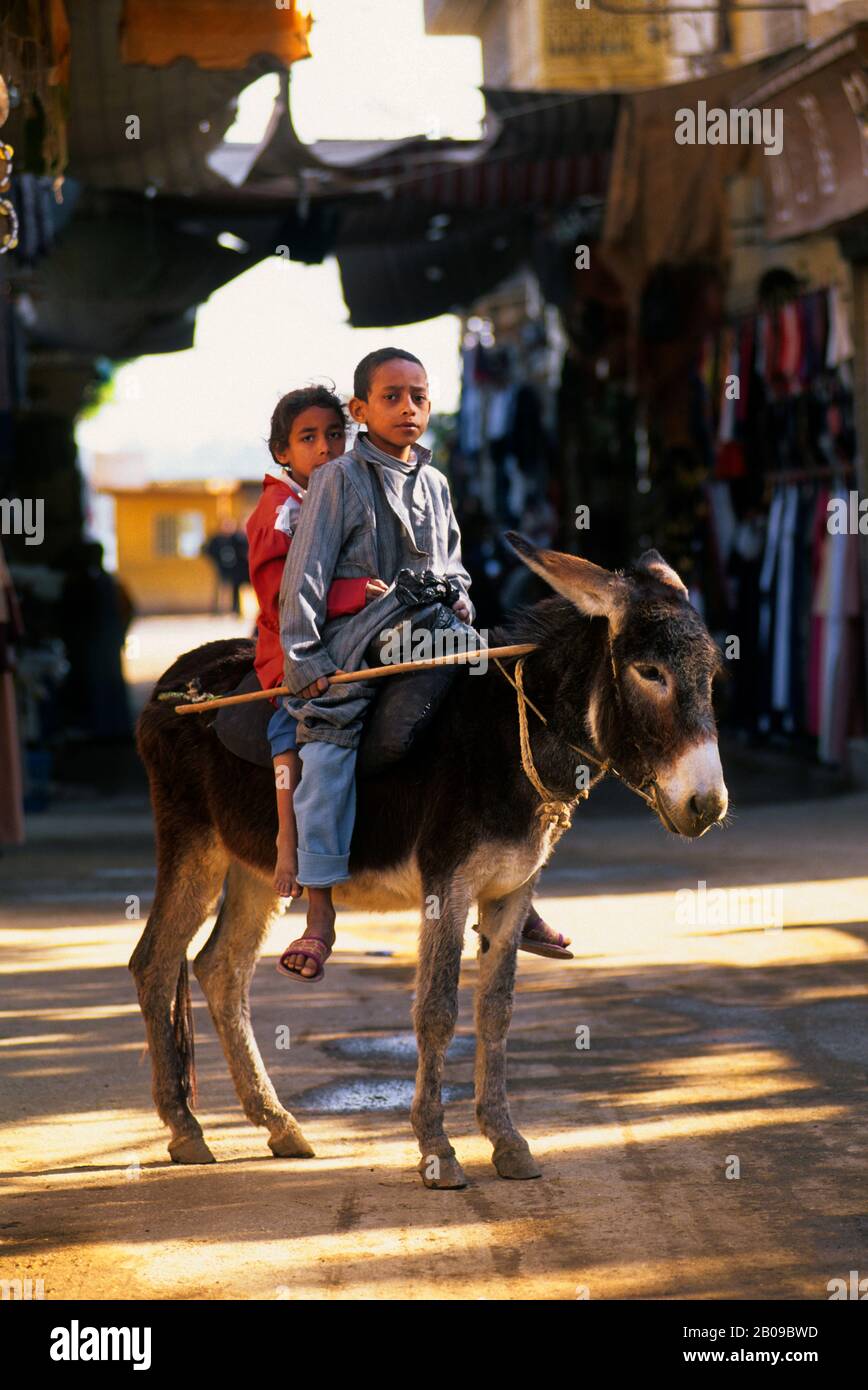 EGYPTE, NIL RIVER, ESNA, SCÈNE DE RUE, GARÇON ET FILLE SUR ÂNE Banque D'Images