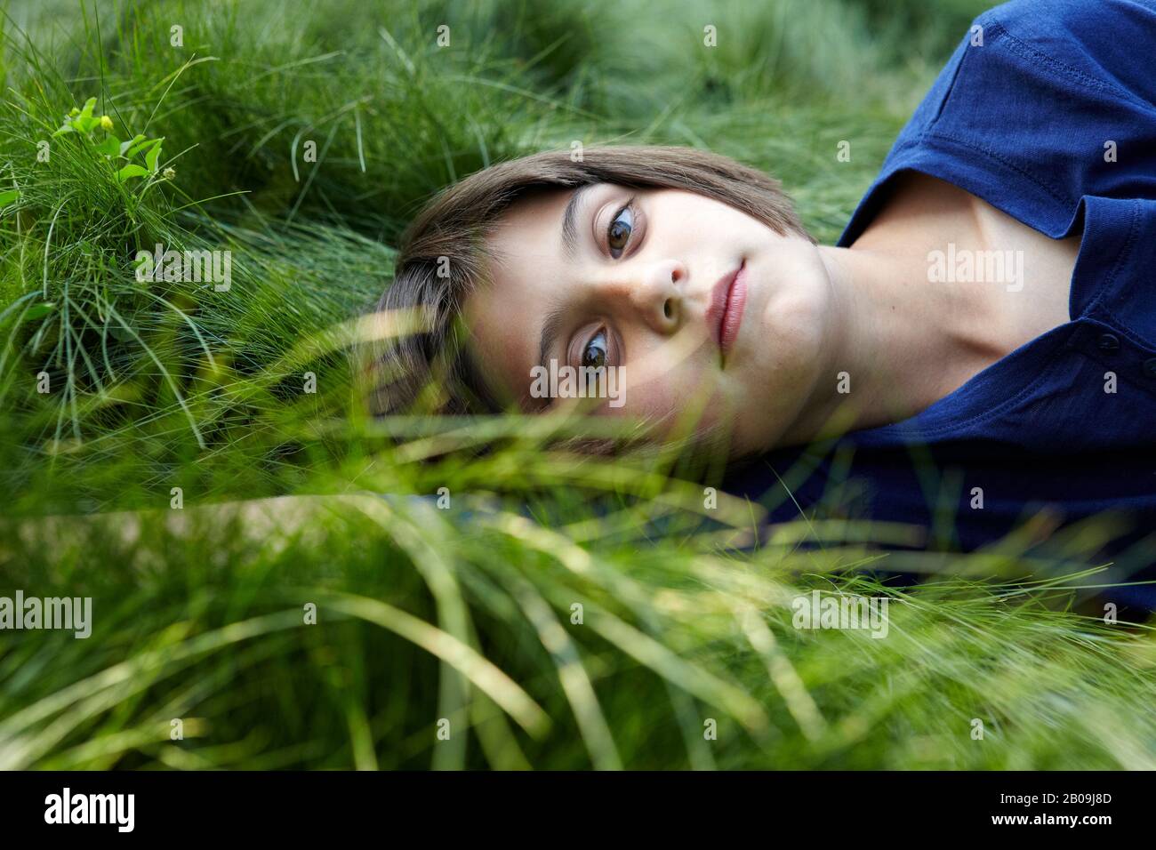 belle jeune fille posée dans l'herbe verte Banque D'Images