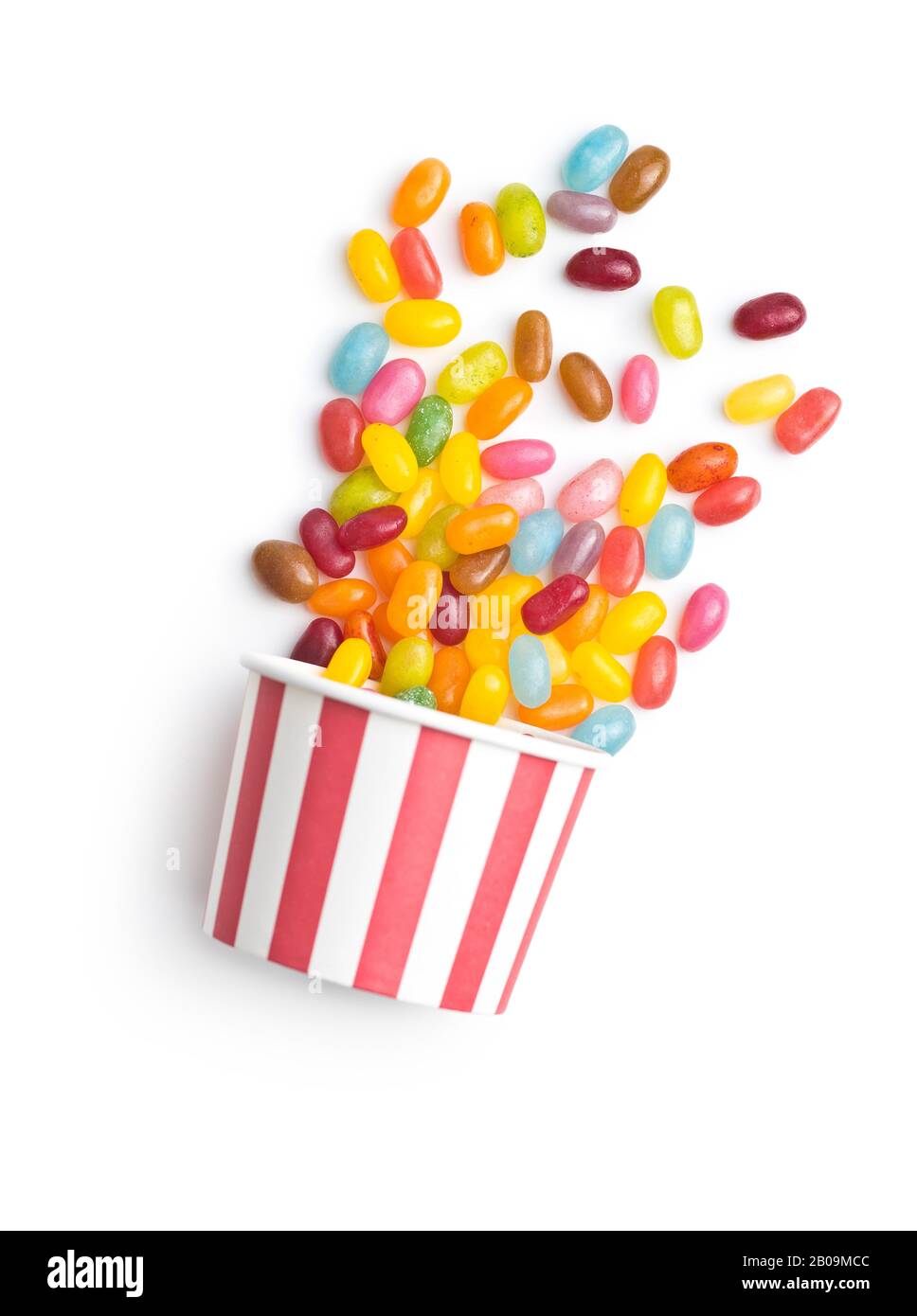 Haricots jaunes fruités. Délicieux haricots de gelée colorés dans une tasse en papier isolée sur fond blanc. Banque D'Images