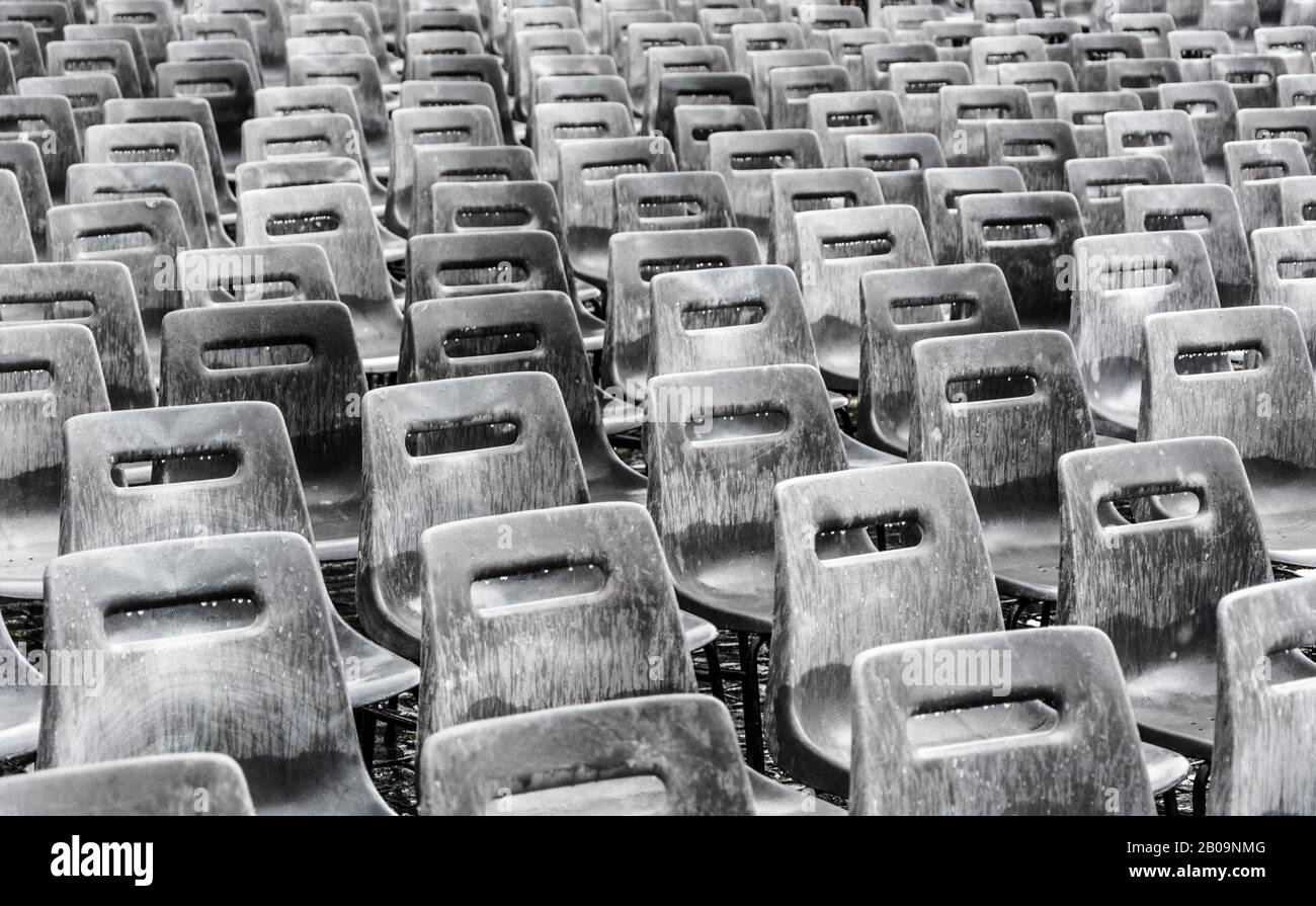 Des rangées de chaises gris vide sous la pluie, l'arrière-plan. Banque D'Images