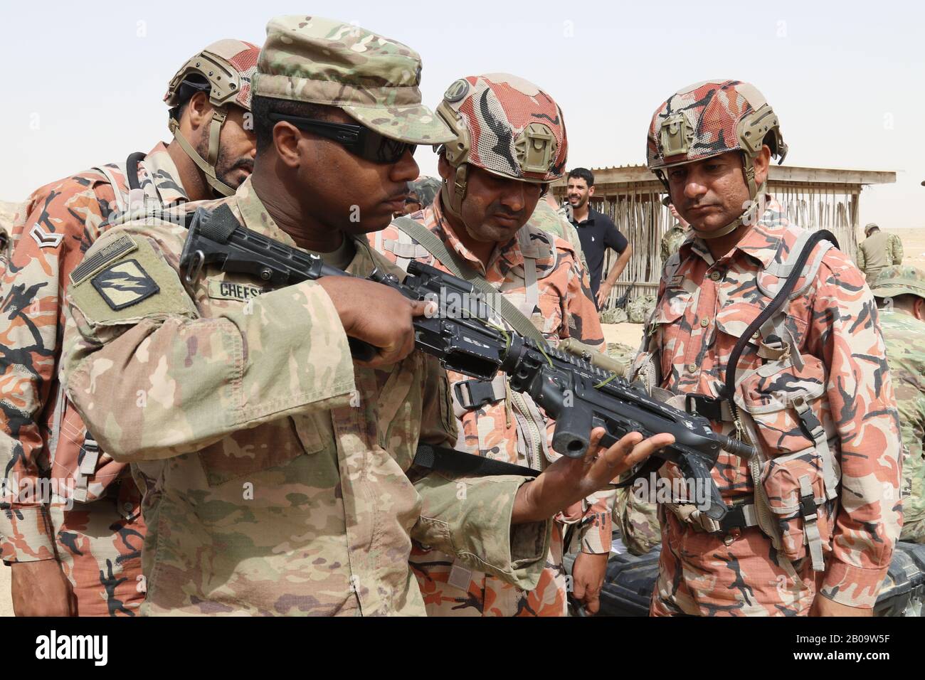 Cps de l'armée américaine. Reginald Cheeseboro, de la 155ème équipe de combat de la Brigade blindée, à gauche, montre aux soldats omanais sa carabine M 4 à une portée de fusil le 20 janvier 2019 à Thumrait, Oman. Banque D'Images
