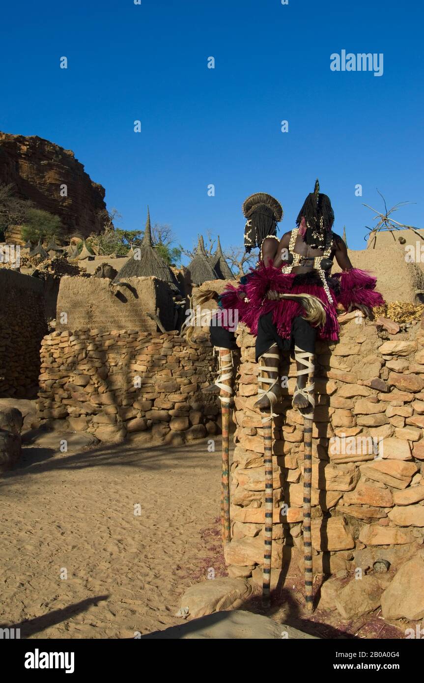 MALI, PRÈS DE BANDIGARA, PAYS DOGON, ESCARPMENT DE BANDIGARA, DANSE TRADITIONNELLE DOGON DANS LE VILLAGE, DANSEUSE SUR PILOTIS HABILLÉS COMME FEMME, (FEMMES INTERDITES Banque D'Images