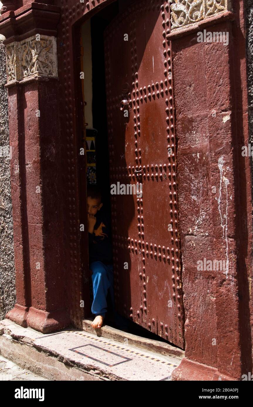 MAROC, CASABLANCA, SCÈNE DE RUE PRÈS DU PALAIS DU ROI, MAISON LOCALE, JEUNE HOMME À LA PORTE Banque D'Images