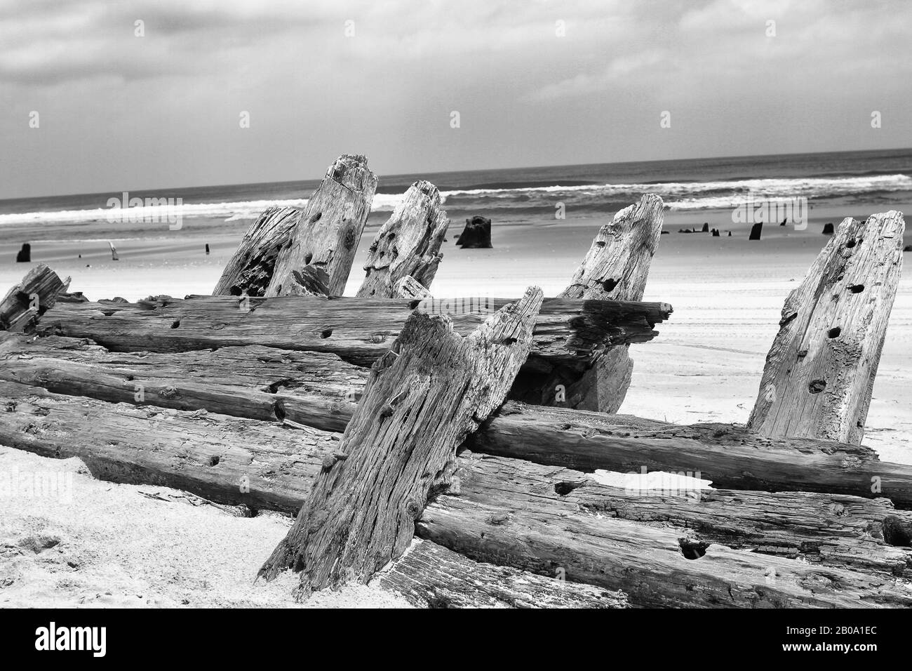 Relique - coque en bois avec épave en bois, avec littoral et surf, noir et blanc. Banque D'Images