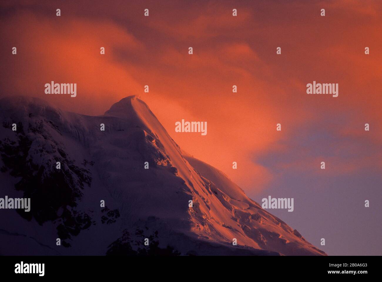 ZONE DE LA PÉNINSULE ANTARCTIQUE, MONTAGNE COUVERTE PAR LE GLACIER À LA LUMIÈRE DU SOLEIL DE MINUIT Banque D'Images