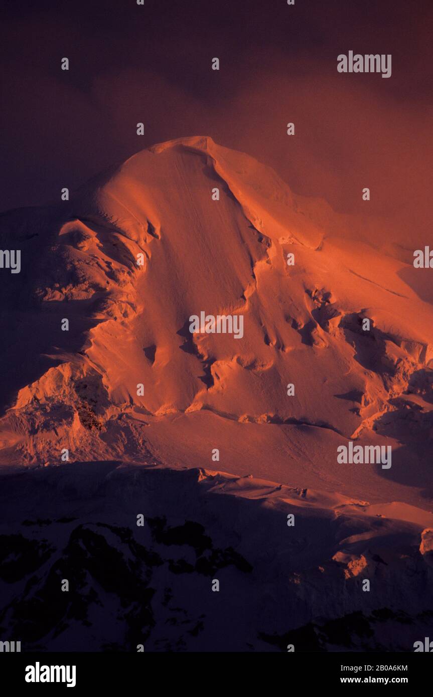 ZONE DE LA PÉNINSULE ANTARCTIQUE, LUMIÈRE DU SOLEIL DE MINUIT SUR LA MONTAGNE COUVERTE PAR LE GLACIER Banque D'Images