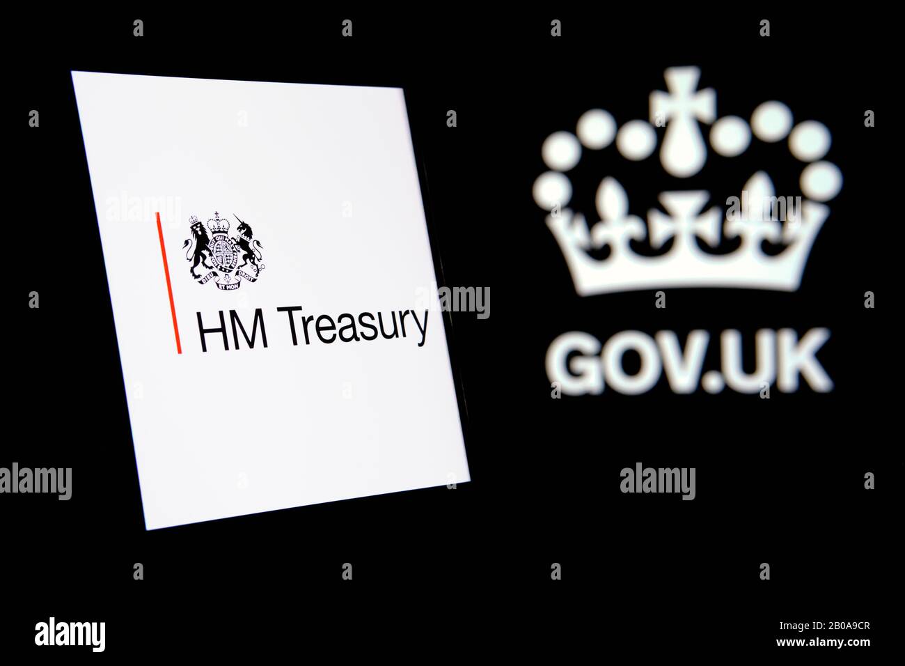 Le logo UK HM Treasury brille sur l'écran du smartphone et le logo gov.uk sur un fond sombre flou. Concept pour le département du gouvernement britannique. Banque D'Images