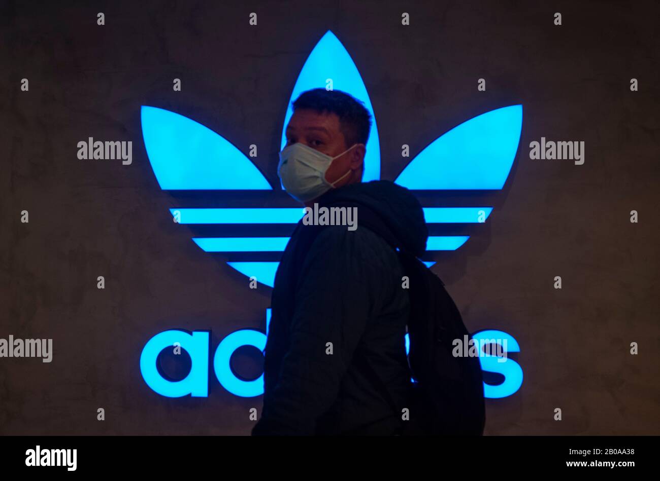 Un piéton passe devant le logo Adidas de la marque multinationale allemande de vêtements de sport à Hong Kong. Banque D'Images
