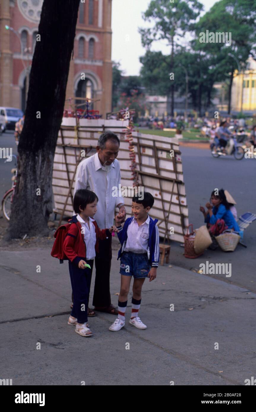 VIETNAM DU SUD, SAIGON, SCÈNE DE RUE, GRAND-PÈRE AVEC ENFANTS D'ÉCOLE Banque D'Images