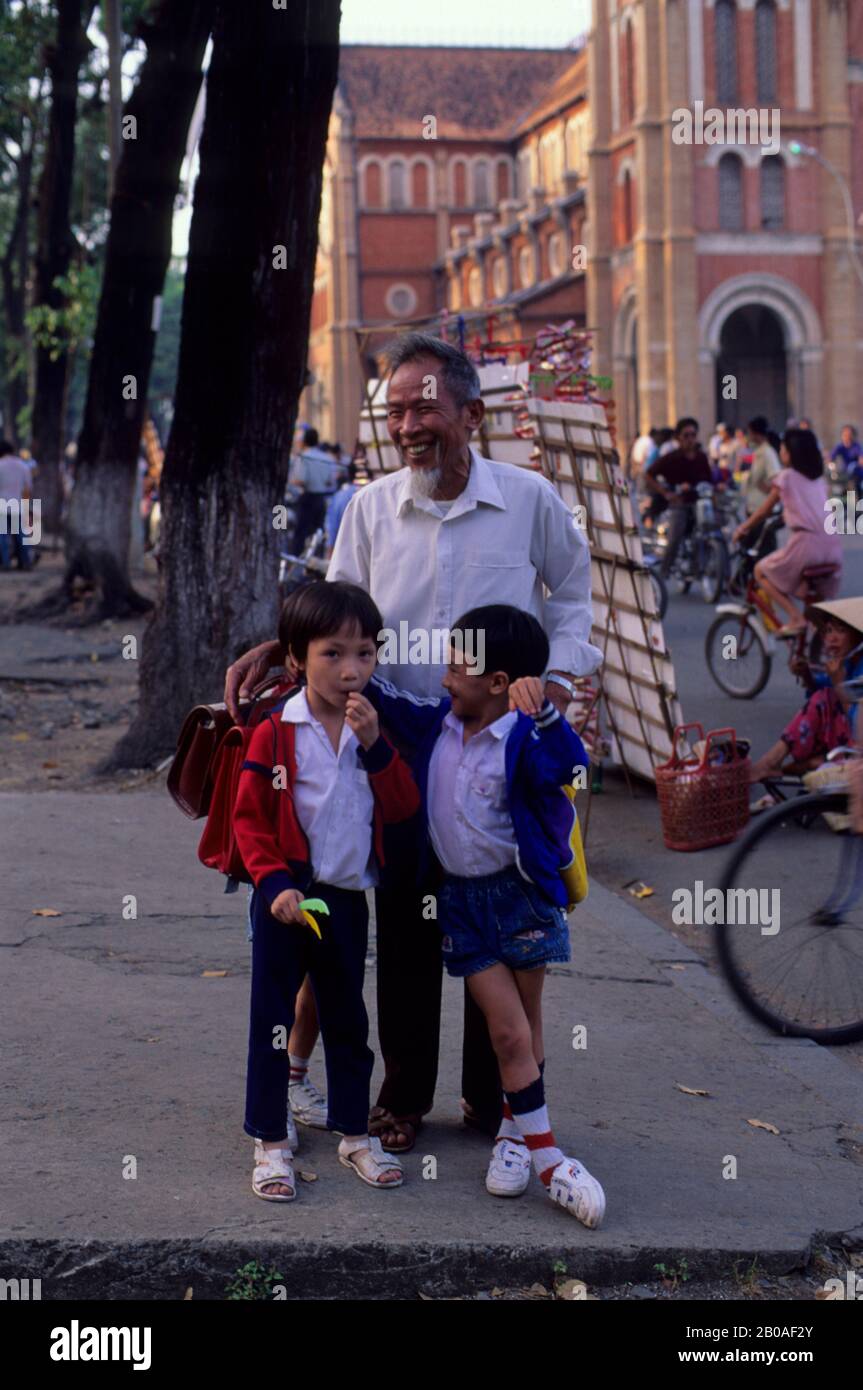 VIETNAM DU SUD, SAIGON, SCÈNE DE RUE, GRAND-PÈRE AVEC ENFANTS D'ÉCOLE Banque D'Images