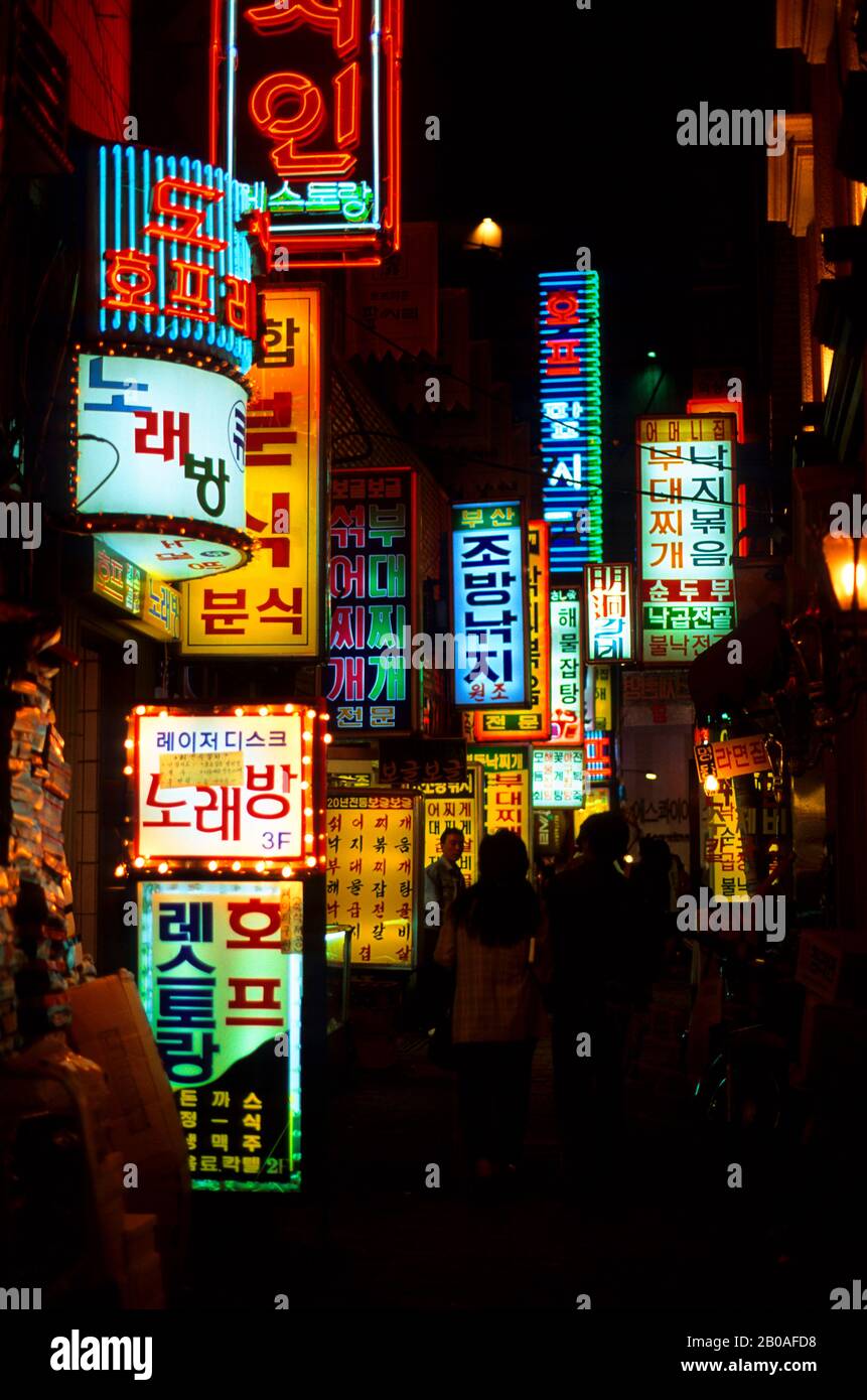 CORÉE, SÉOUL, ZONE COMMERÇANTE MYUNG-DONG LA NUIT AVEC DES ENSEIGNES FLUO COLORÉES Banque D'Images