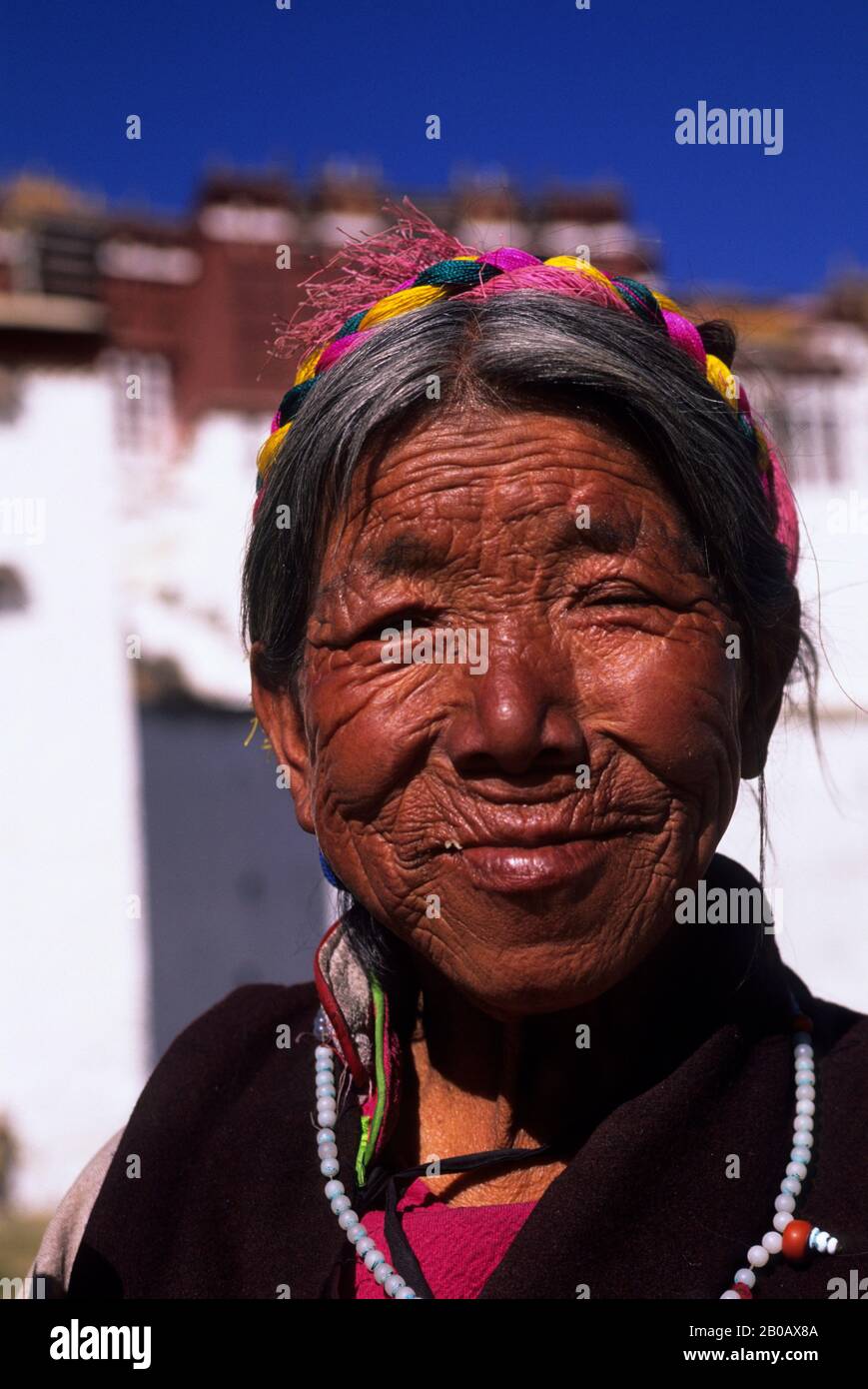 CHINE, TIBET, LHASA, PORTRAIT DE FEMME, POTALA EN ARRIÈRE-PLAN Banque D'Images