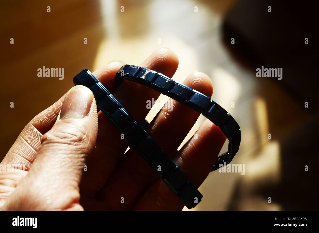 DÉPLACEMENT POLAIRE : un homme exerce son poignet à l'aide d'un bracelet magnétique contenant des pierres tourmaline pour augmenter la force. Banque D'Images