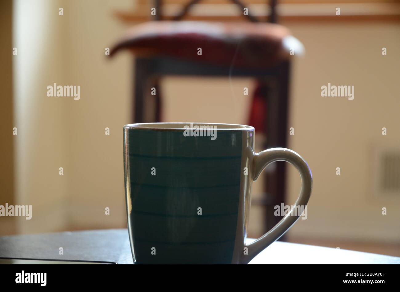 RÔTI DU DIMANCHE : une tasse de café fraîchement préparée repose sur une table de salon. Banque D'Images