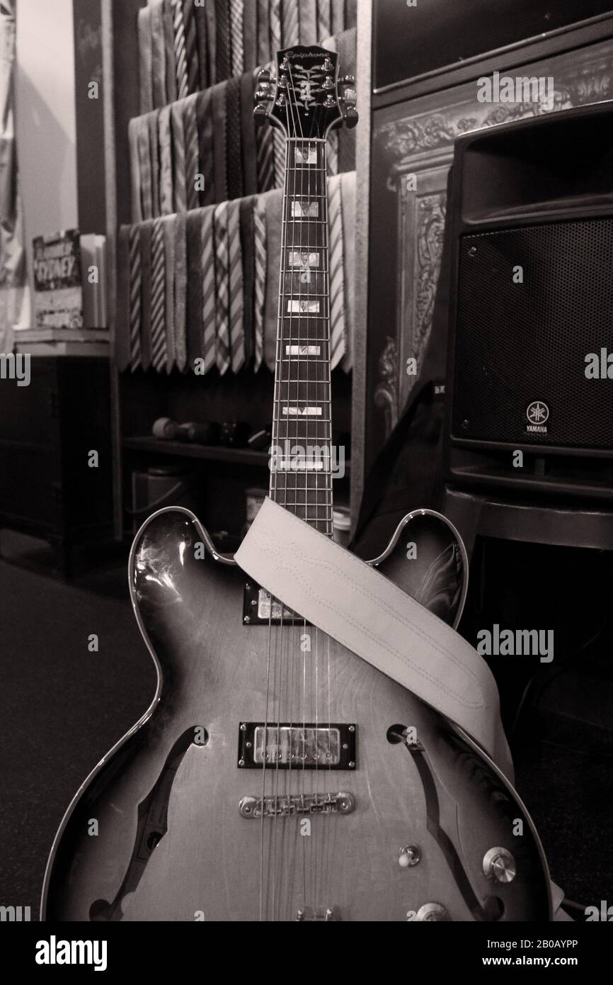 Guitare acoustique électrique et haut-parleurs instruments de musique en noir et blanc photos de la vie dans un magasin de vêtements pour hommes sur mesure avec chemises et cravates Banque D'Images