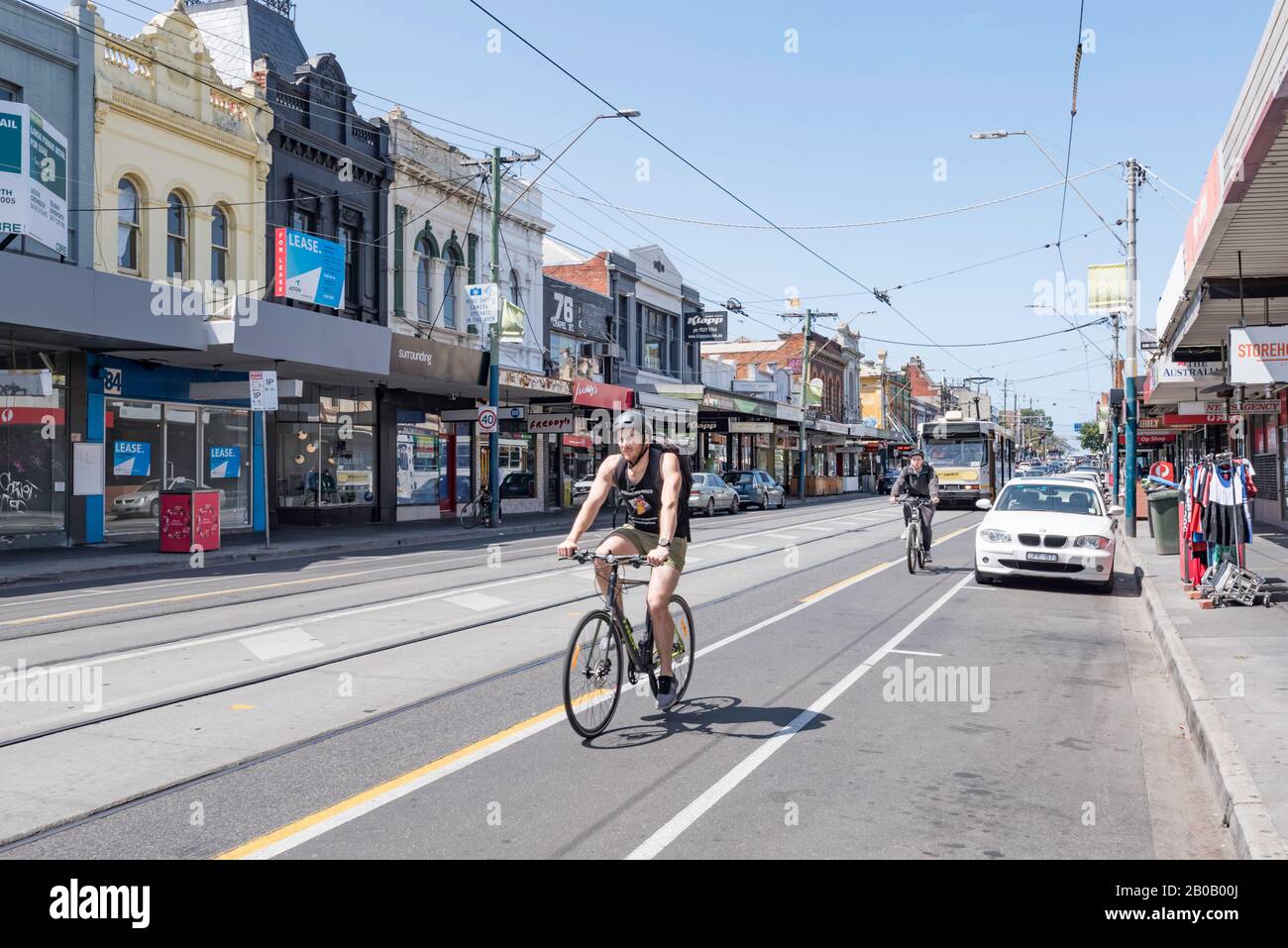 Les cyclistes qui pédalier sur une piste cyclable dédiée sur Chapel Street, Windsor, Melbourne, Australie avec un tram qui suit sur la même route Banque D'Images