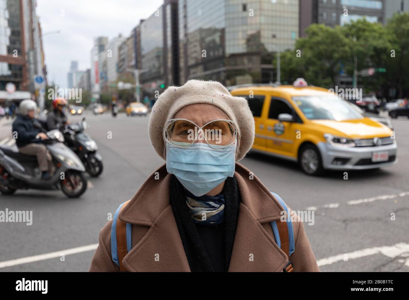 Femme taiwanaise dans la rue animée de Taipei portant un masque facial pour se protéger contre l'épidémie de coronavirus covid-19. Banque D'Images