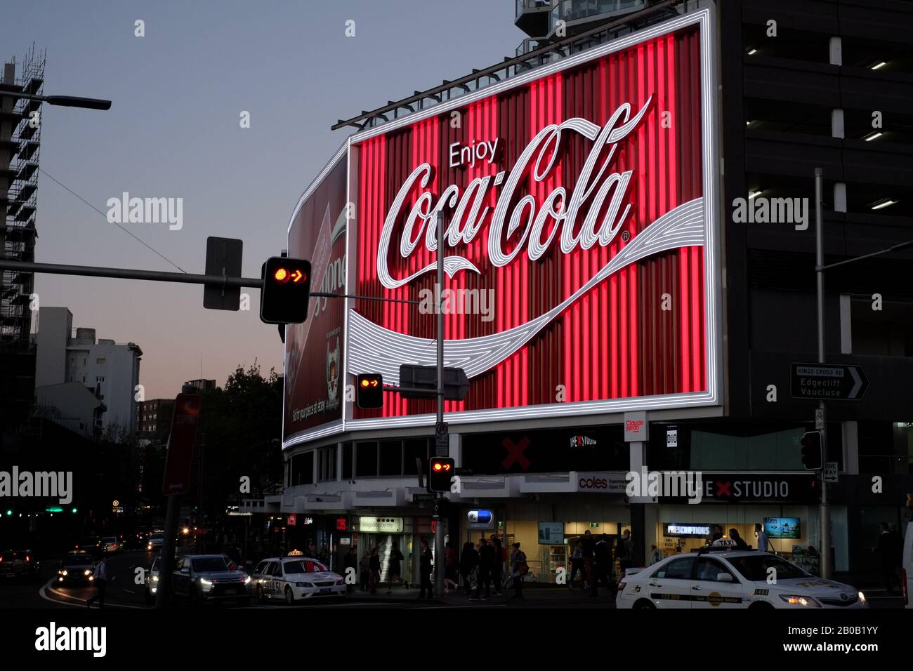 Le panneau Kings Cross Coke, juste après avoir été remplacé en 2016, est éclairé par un éclairage net en soirée, une scène de rue avec circulation, crépuscule Banque D'Images