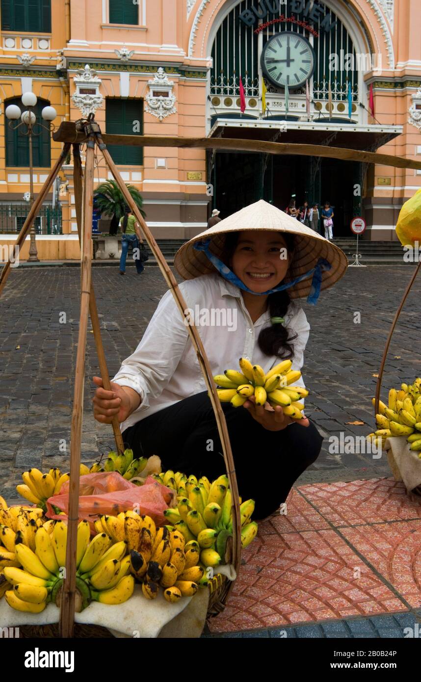 VIETNAM, SAIGON (HO CHI MINH VILLE), BUREAU CENTRAL DE POSTE, STYLE COLONIAL FRANÇAIS, FEMME VENDANT DES BANANES, NON LA (CONE HAT) Banque D'Images