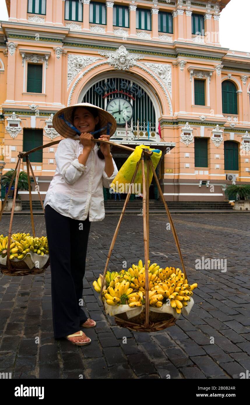 VIETNAM, SAIGON (HO CHI MINH VILLE), BUREAU CENTRAL DE POSTE, STYLE COLONIAL FRANÇAIS, FEMME VENDANT DES BANANES, NON LA (CONE HAT) Banque D'Images