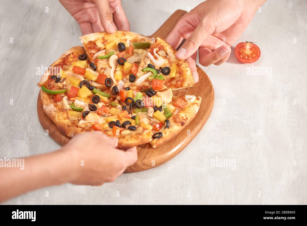 Hands holding fresh baked pizza au fromage de fusion. Banque D'Images