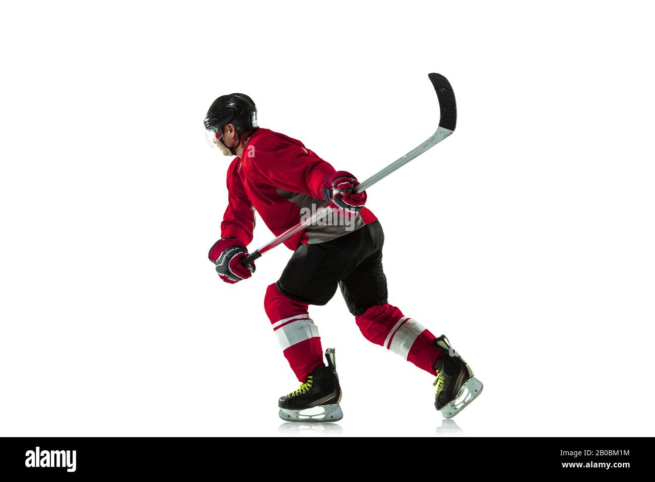 Notation d'un objectif. Joueur de hockey masculin avec le bâton sur la cour de glace et fond blanc. Sportif portant de l'équipement et du casque pratiquant. Concept de sport, mode de vie sain, mouvement, mouvement, action. Banque D'Images