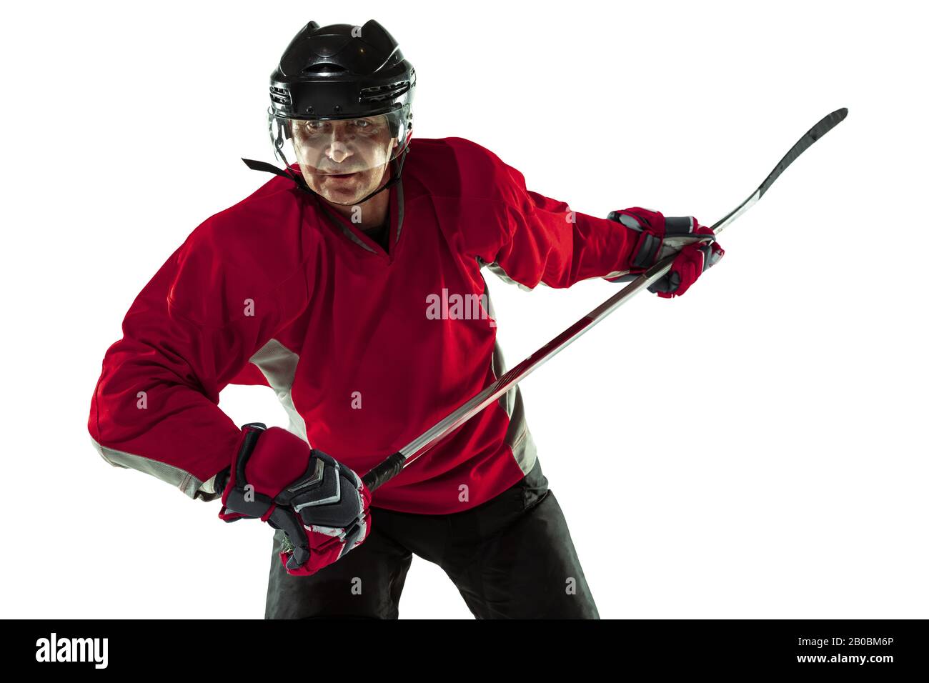 Notation d'un objectif. Joueur de hockey masculin avec le bâton sur la cour de glace et fond blanc. Sportif portant de l'équipement et du casque pratiquant. Concept de sport, mode de vie sain, mouvement, mouvement, action. Banque D'Images