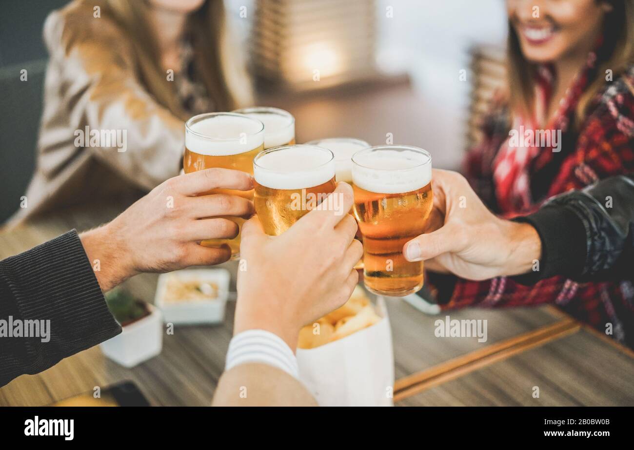 Groupe d'amis qui apprécient une bière dans la brasserie pub vintage - les jeunes mains applaudissaient au bar restaurant - amitié, fête, vie nocturne et la conce des jeunes Banque D'Images