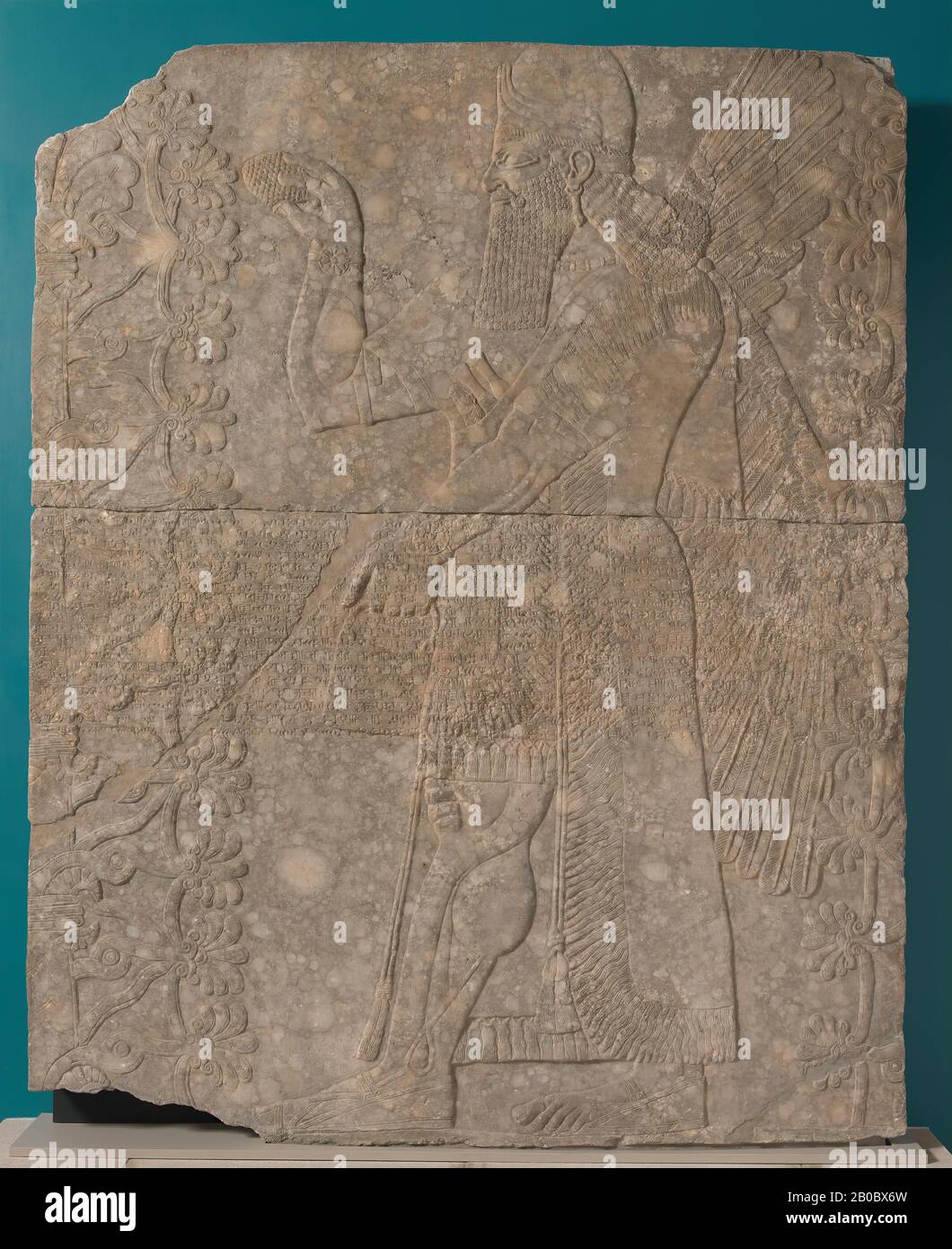 Artiste inconnu, secours assyrien : Esprit ailé ou Apkallu et arbre sacré de Kalhu (Nimrud), Irak, Palais du Nord-Ouest, salle T, panneau 6, CA. 875–860 B.C.E., gypse (Mossoul alabaster), 91 7/16 po. X 73 3/16 po. X 5 7/16 po. (232,2 cm. X 185,9 cm. X 13,8 cm.), la figure aidée, ou l'esprit d'apkallu, est souvent mentionnée dans les textes assyriens. Avec des pouvoirs magiques et protecteurs, il sert à protéger le roi et son Royaume. La couronne hurissante annonce sa divinité, bien que son portrait porte une ressemblance onctueuse à Ashurnasirpal lui-même. Il tient un seau dans sa main gauche, tandis que dans sa droite, il saume a s. Banque D'Images
