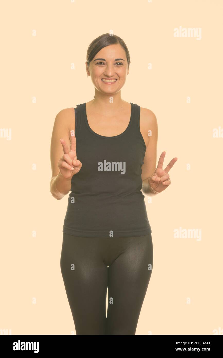 Studio shot of woman smiling tout en signe de paix avec les deux mains Banque D'Images