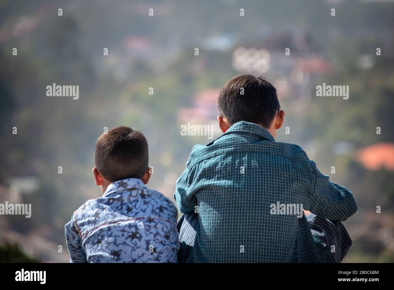 Kalaw, Myanmar - Février 2020: Scène idyllique avec deux jeunes garçons dans des chemises colorées, dos à l'appareil photo, vue sur la distance. Banque D'Images